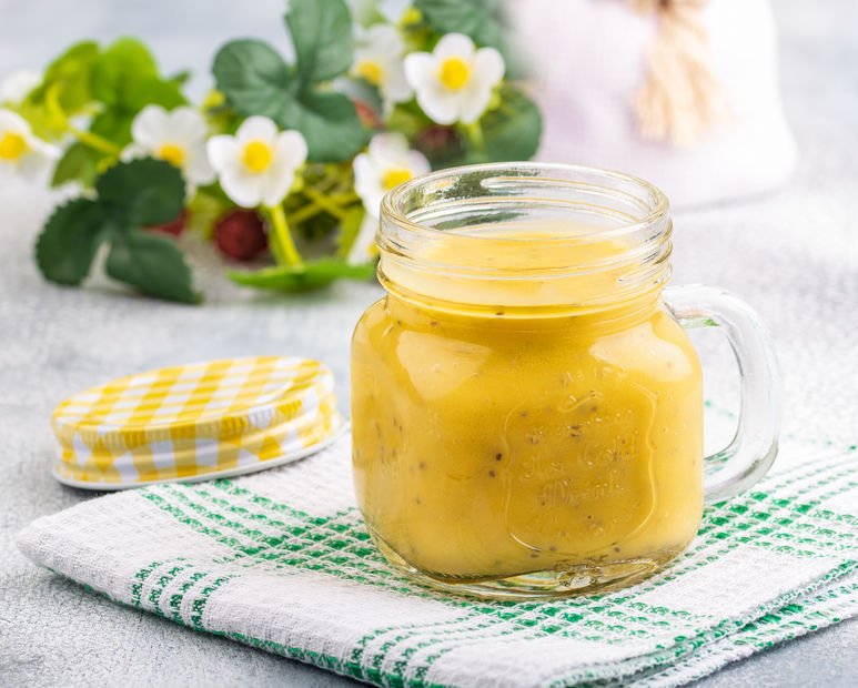 Avo Mango Smoothie in clear glass on white background