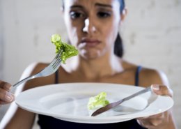 mujer comiendo lechuga en plato blanco