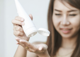 Mujer aplicándose loción en las manos