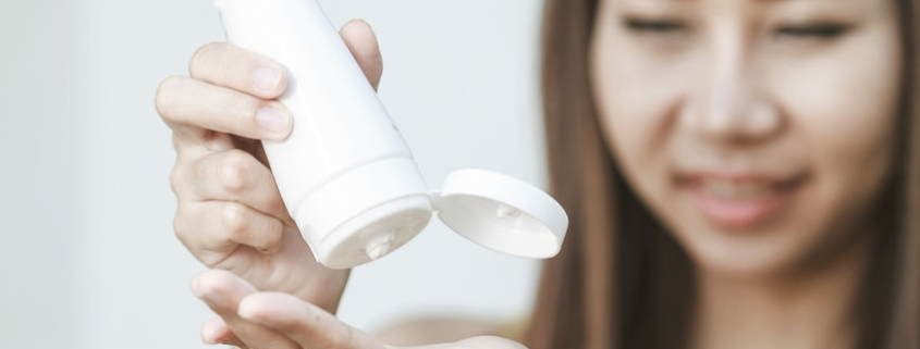 Woman applying lotion to hands