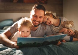 Padre leyendo a sus hijos antes de dormir