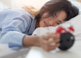 woman looking at alarm clock in morning