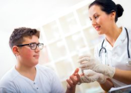 boy getting blood glucose checked by doctor