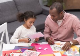 daughter and dad creating card for mothers day