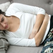 woman with stomach ache resting on couch